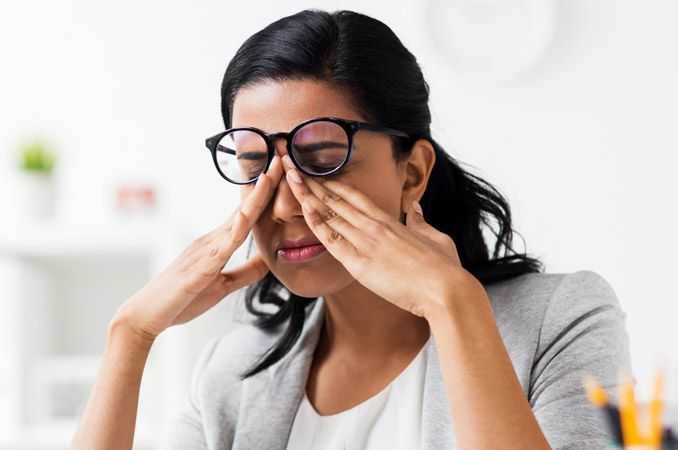 Woman rubbing her eyes to deal with eyelid twitching