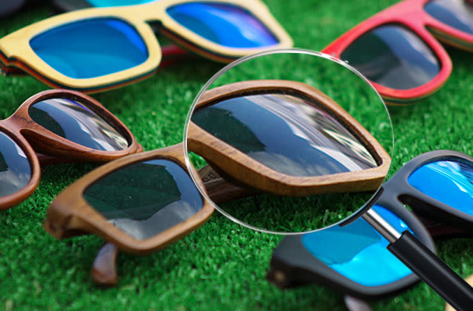 Multiple pairs of wayfarer sunglasses on green turf