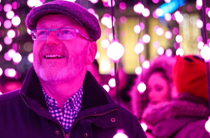 Middle-aged man wearing progressive lensed eyeglasses while looking at holiday lights