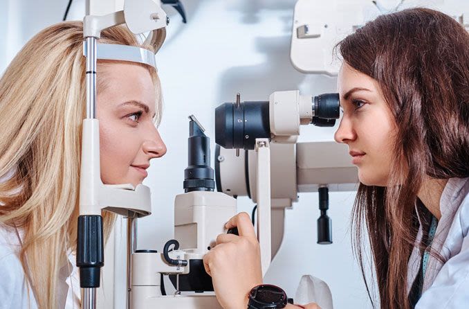 Woman performing eye exam on another woman