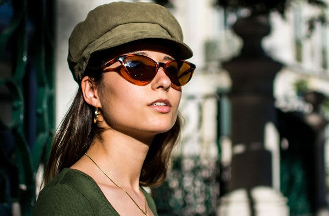 Woman wearing green hat and non-prescription sunglasses.