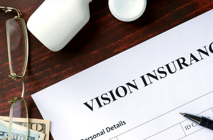 vision insurance form on desk next to reading glasses and cash